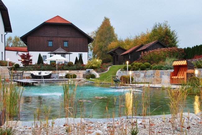 Schwimmteich mit Haus im Hintergrund